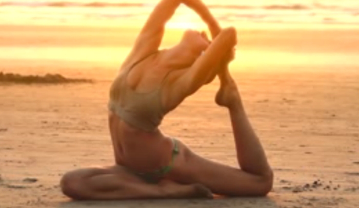 Bijzondere vrouw doet aan yoga op het strand