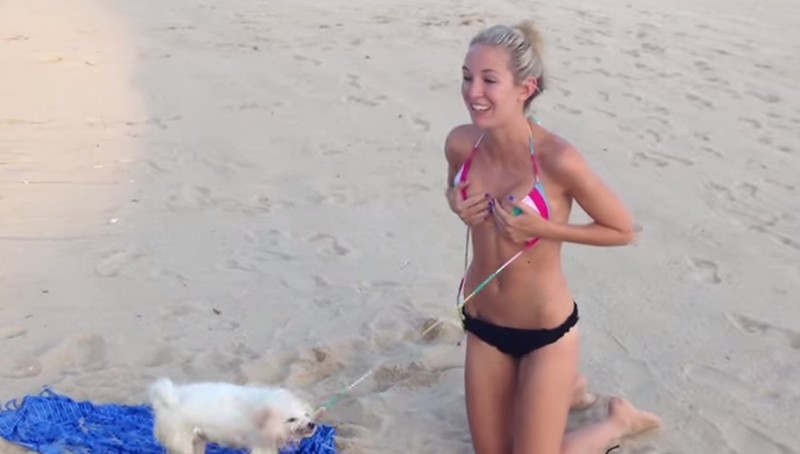 Vrouw wil relaxen op het strand, hond vindt dat ze topless moet